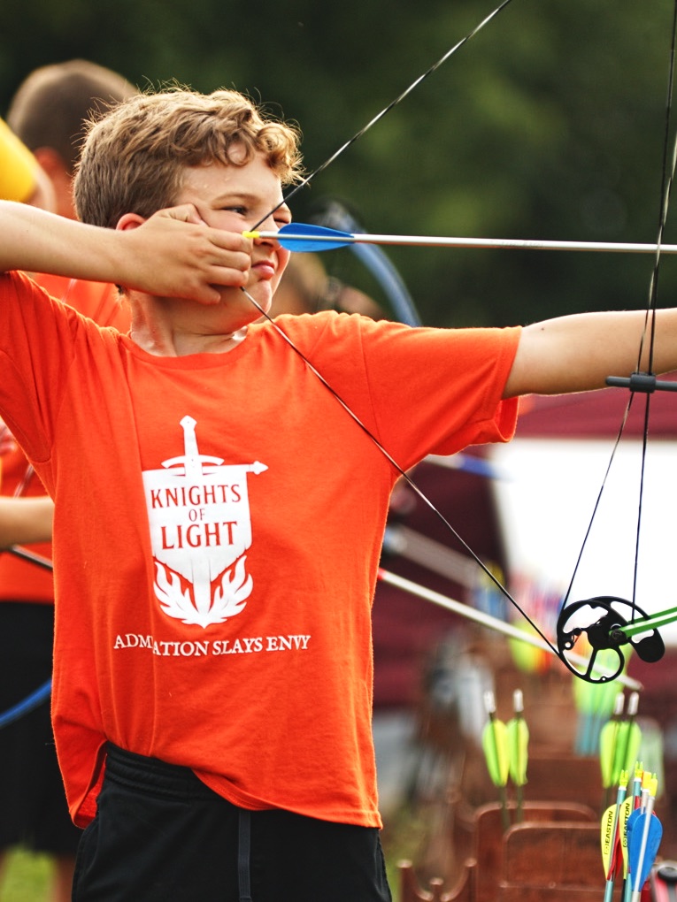 A young Knight of Light drawing his bow at archery practice